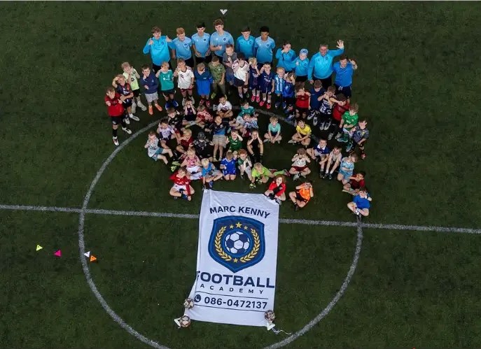 Summer camp group photo from above around the academy banner
