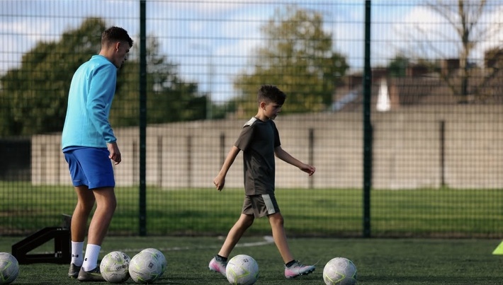 Coach passing to a young player