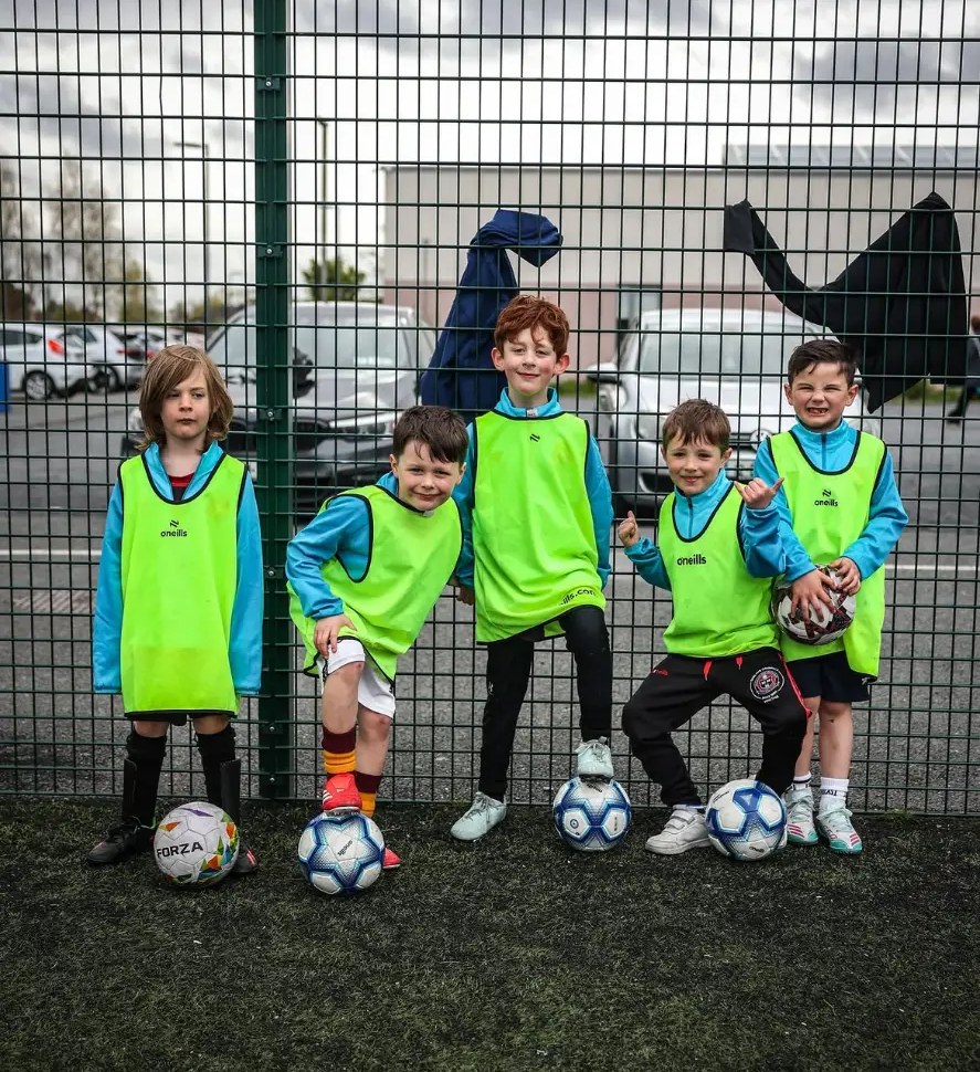 Young players in bibs with footballs